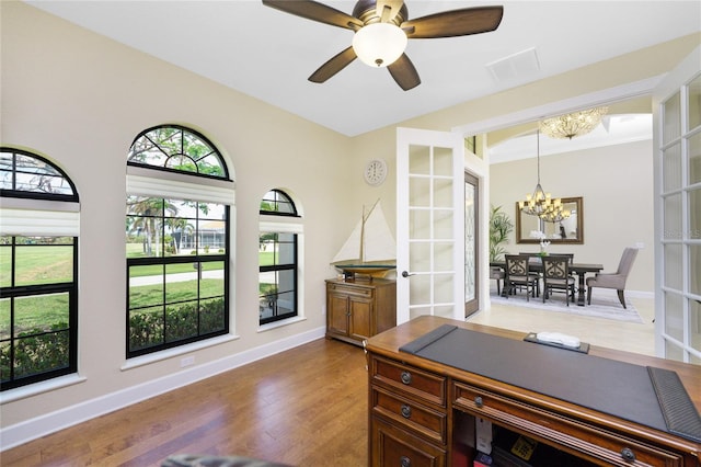 office featuring hardwood / wood-style floors, french doors, and ceiling fan with notable chandelier