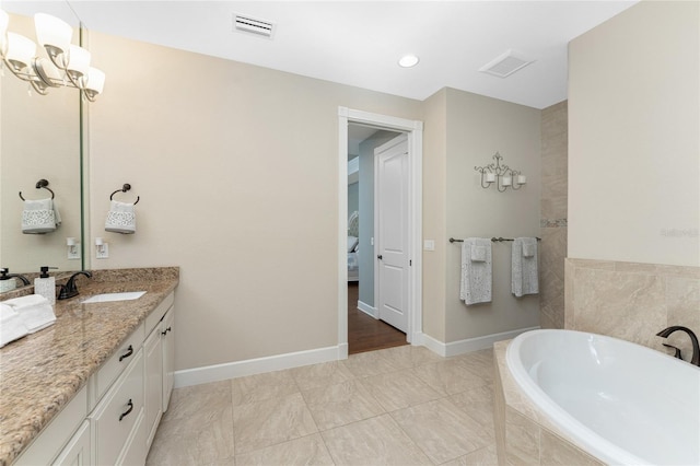 bathroom with vanity and a relaxing tiled tub