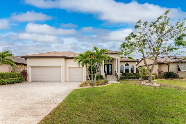 mediterranean / spanish house with a garage and a front lawn