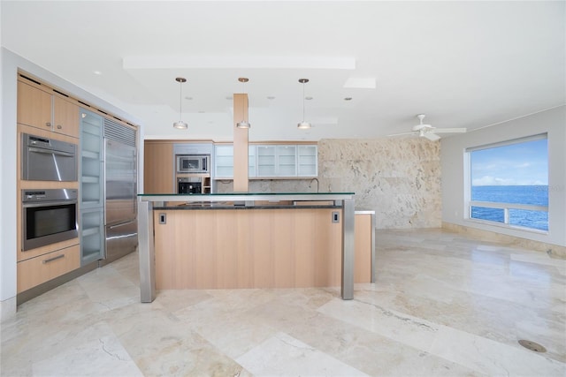 kitchen featuring dark countertops, marble finish floor, modern cabinets, and built in appliances