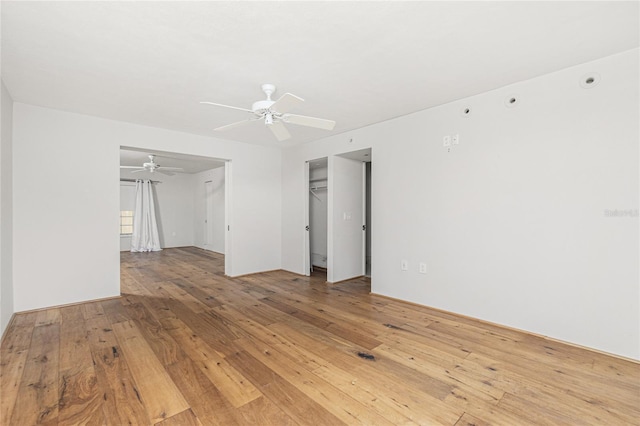 empty room with a ceiling fan and light wood finished floors