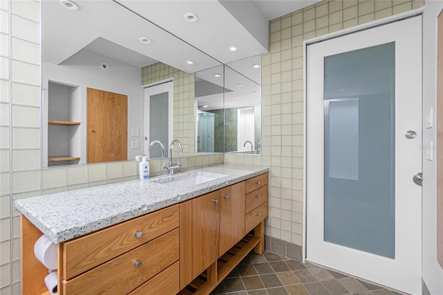 bathroom with vanity, tile walls, and walk in shower