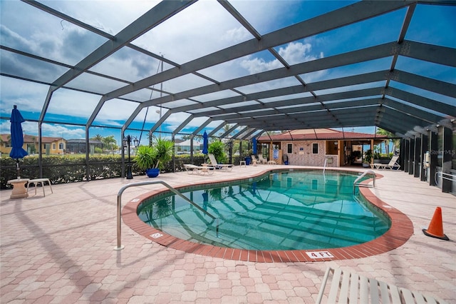 community pool with glass enclosure and a patio area