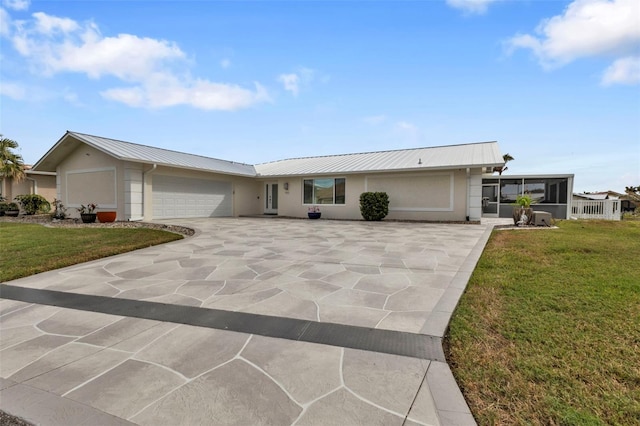 ranch-style house with a sunroom, a front lawn, and a garage