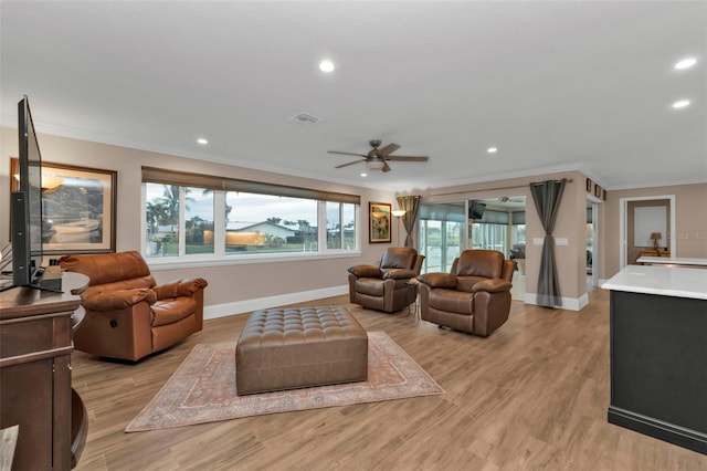 living room with ceiling fan, ornamental molding, and light hardwood / wood-style flooring