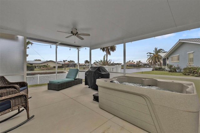 view of patio / terrace featuring a ceiling fan, a hot tub, fence, a water view, and a grill