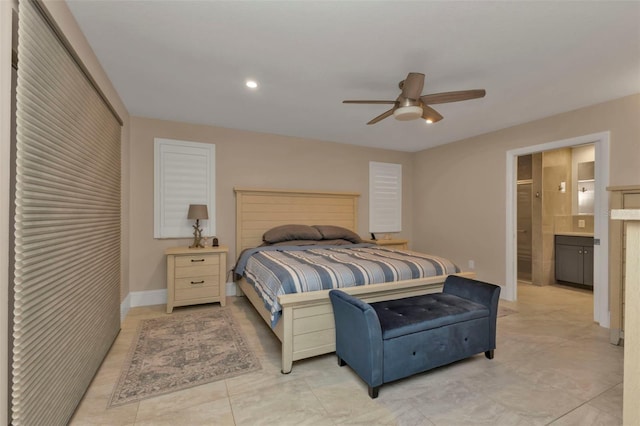 bedroom with baseboards, ceiling fan, and ensuite bath
