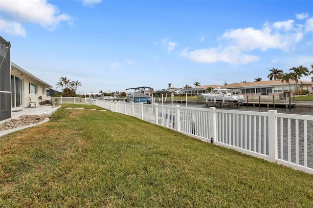 view of yard featuring a fenced backyard, a water view, and a residential view