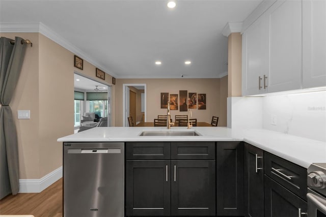 kitchen with white cabinetry, kitchen peninsula, crown molding, appliances with stainless steel finishes, and light wood-type flooring