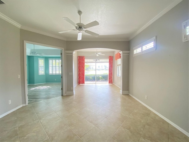 unfurnished room with ceiling fan, a wealth of natural light, ornamental molding, and light tile patterned flooring