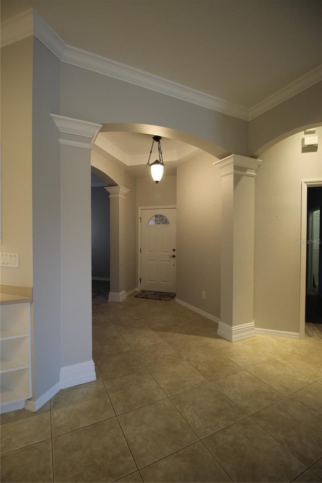 foyer with decorative columns, crown molding, and tile patterned floors