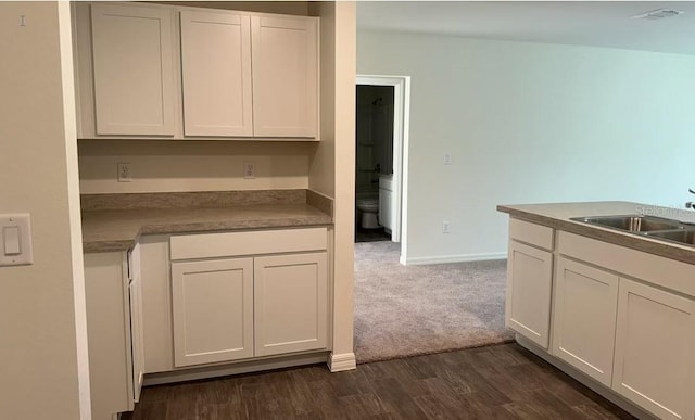 kitchen featuring white cabinetry, dark hardwood / wood-style flooring, and sink