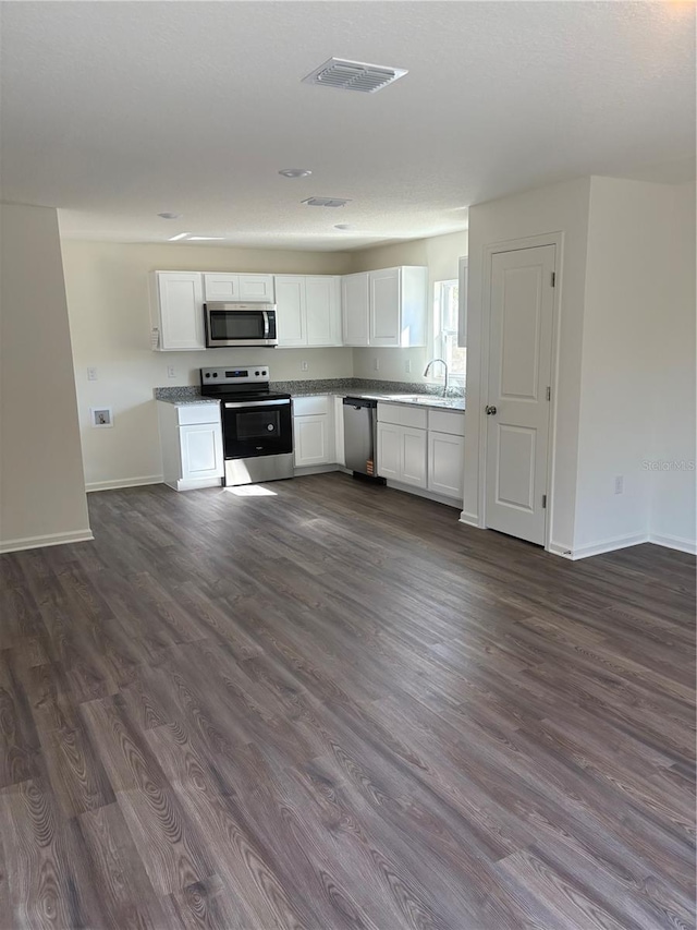 kitchen with stainless steel appliances, sink, dark wood-type flooring, and white cabinets