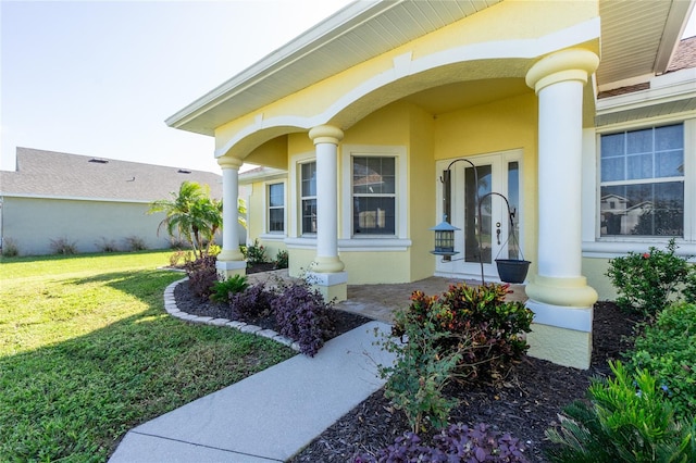 doorway to property featuring a porch and a yard