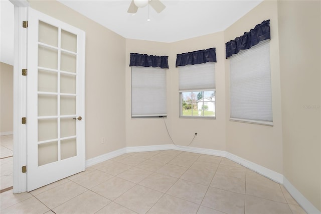 tiled spare room featuring ceiling fan