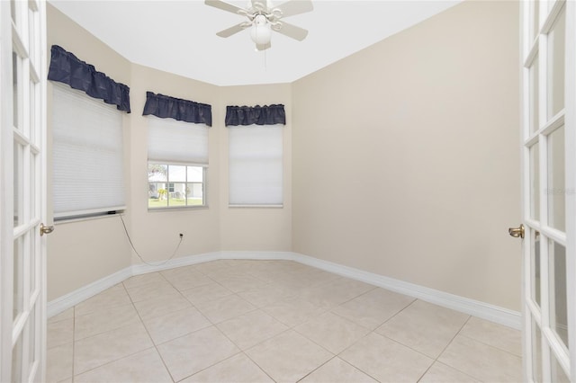 empty room with ceiling fan and light tile patterned floors