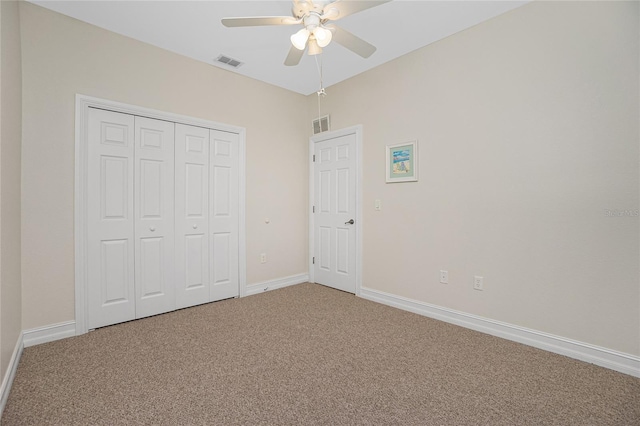 unfurnished bedroom featuring carpet floors, ceiling fan, and a closet