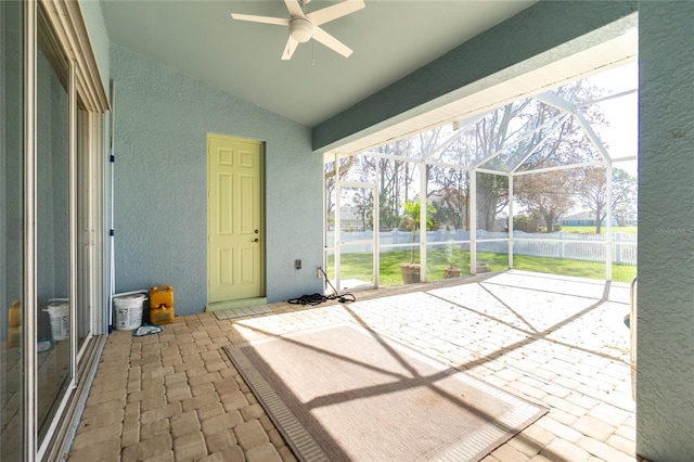 unfurnished sunroom featuring a wealth of natural light, lofted ceiling, and ceiling fan