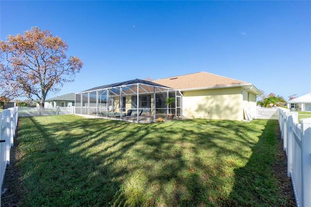 back of property featuring glass enclosure, a yard, and a patio