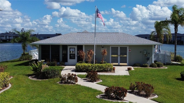 rear view of property featuring a yard and a water view