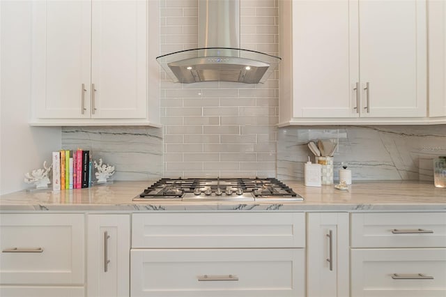 kitchen featuring wall chimney exhaust hood, decorative backsplash, and white cabinetry