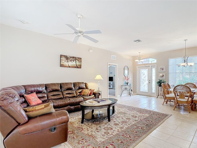 living room with ceiling fan with notable chandelier and light tile patterned floors