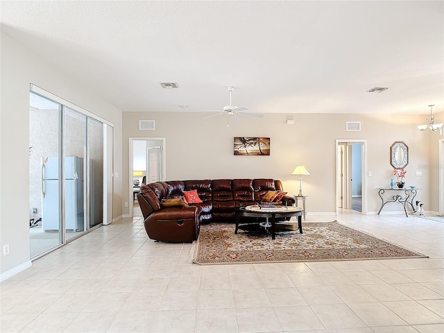 tiled living room featuring ceiling fan with notable chandelier