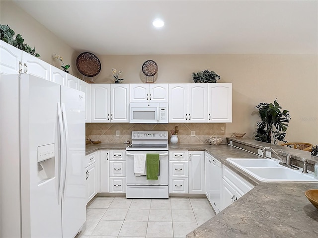 kitchen with backsplash, sink, light tile patterned flooring, white cabinets, and white appliances