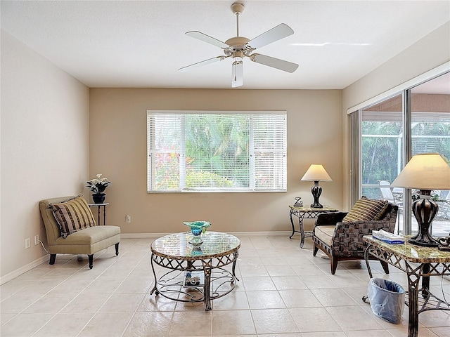 living area with ceiling fan and light tile patterned floors