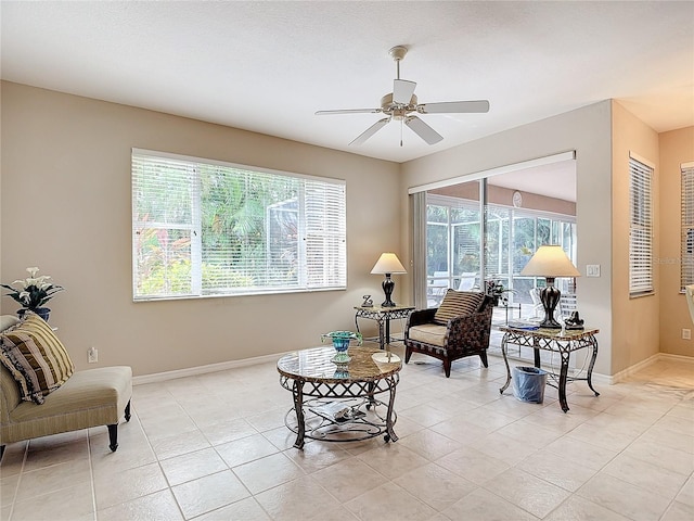 living area with ceiling fan and light tile patterned floors