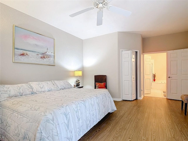 bedroom with hardwood / wood-style floors, ensuite bathroom, and ceiling fan