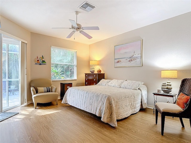 bedroom with ceiling fan, multiple windows, hardwood / wood-style floors, and access to exterior