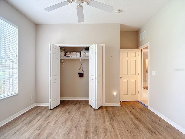 unfurnished bedroom with light hardwood / wood-style floors, a closet, and ceiling fan