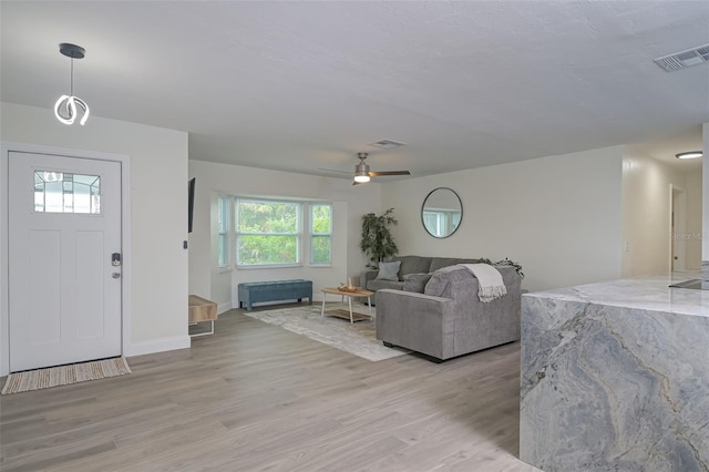 living room featuring ceiling fan, light hardwood / wood-style floors, and plenty of natural light