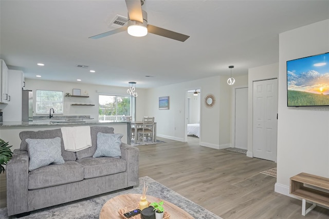 living room featuring light wood-type flooring and ceiling fan