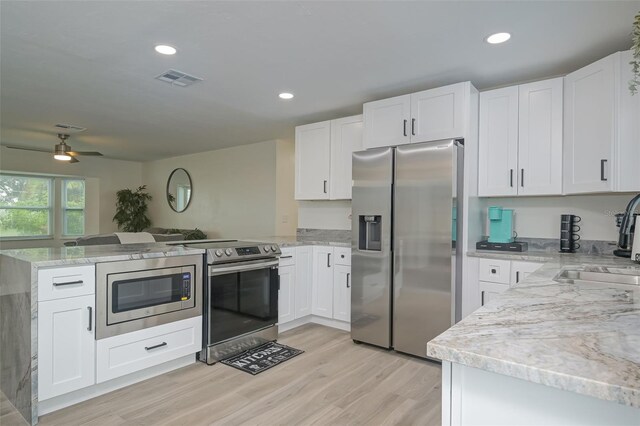 kitchen featuring white cabinetry, stainless steel appliances, and kitchen peninsula