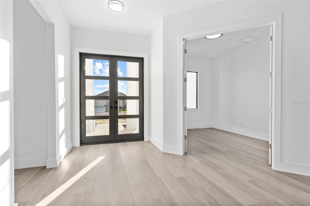 foyer with french doors and light hardwood / wood-style flooring