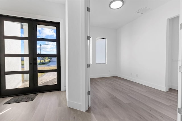 foyer entrance featuring french doors and light wood-type flooring