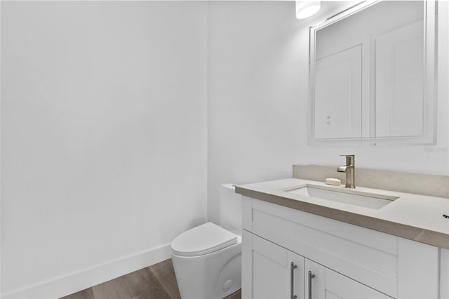 bathroom with vanity, hardwood / wood-style flooring, and toilet