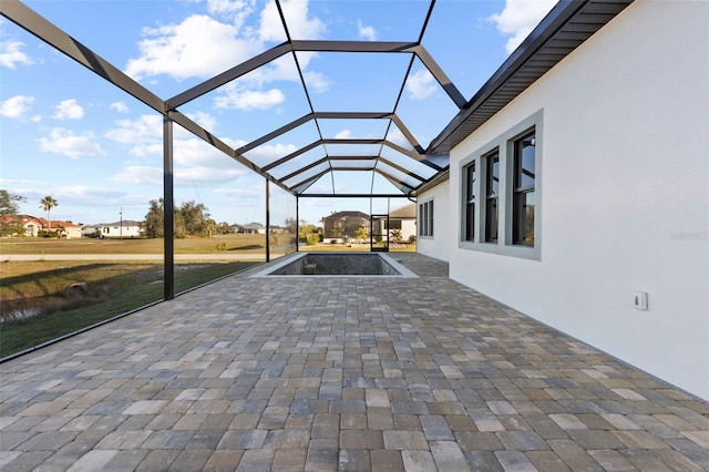 view of patio / terrace featuring glass enclosure and a pool