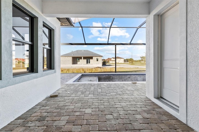 view of patio / terrace featuring glass enclosure