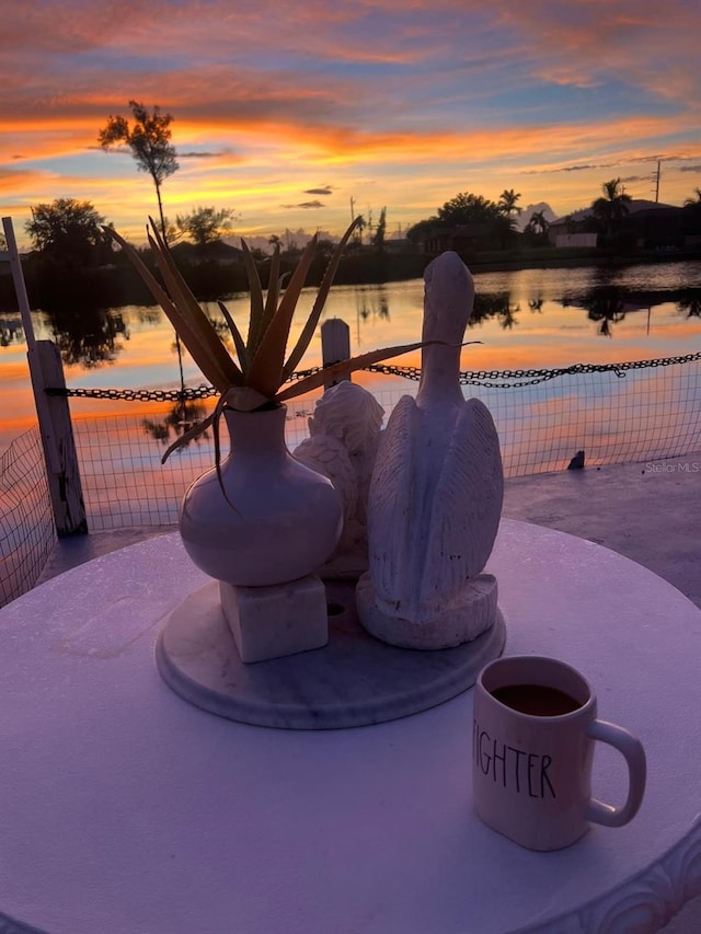 patio terrace at dusk featuring a water view