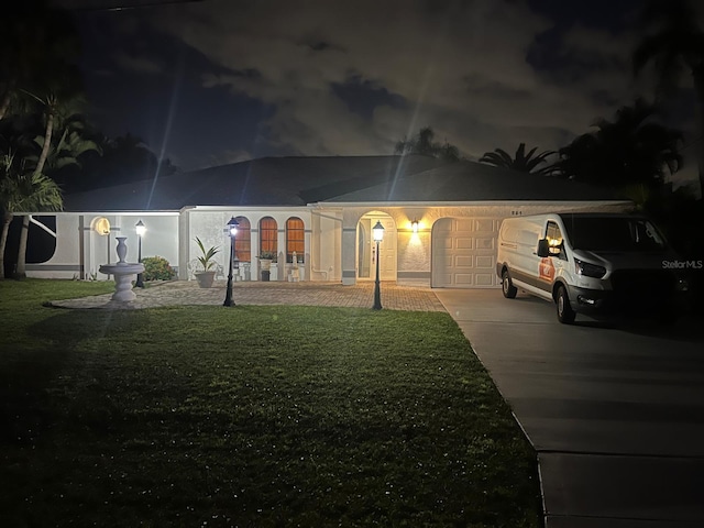 ranch-style home featuring a yard and a garage