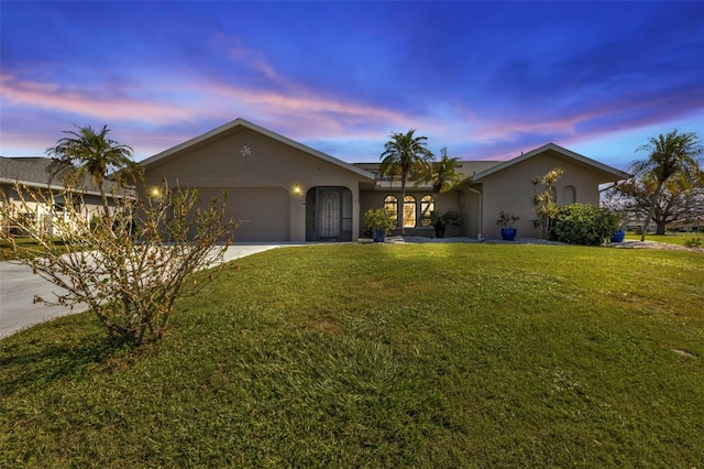 single story home featuring a yard and a garage