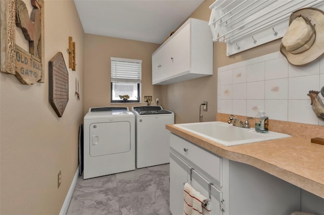 laundry area with sink, independent washer and dryer, and cabinets