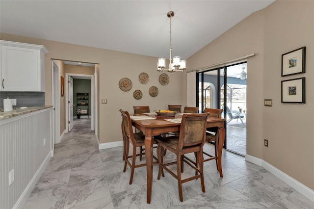 dining area featuring a notable chandelier and vaulted ceiling