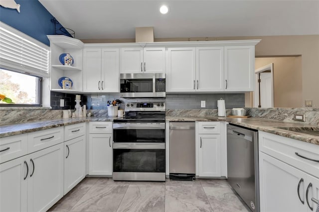 kitchen featuring light stone countertops, decorative backsplash, white cabinets, and stainless steel appliances