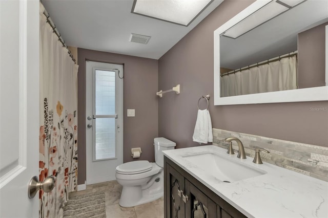 bathroom with vanity, decorative backsplash, toilet, and tile patterned flooring