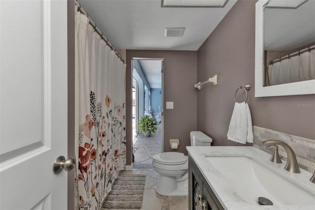 bathroom featuring vanity, toilet, and tile patterned flooring