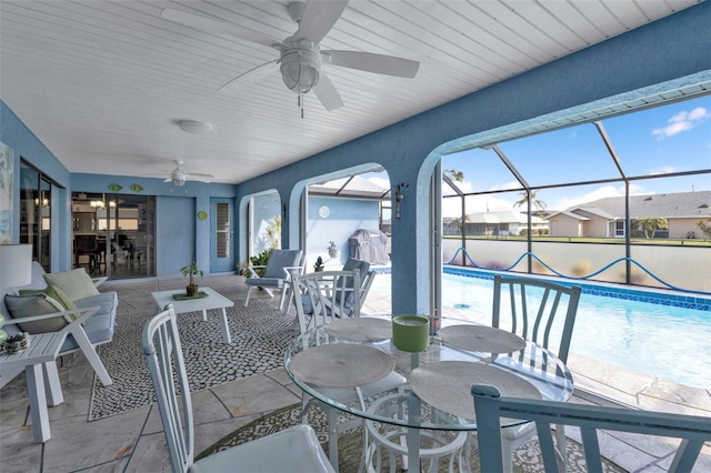 view of patio with ceiling fan and a lanai